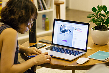 A person sitting at a table using a laptop.